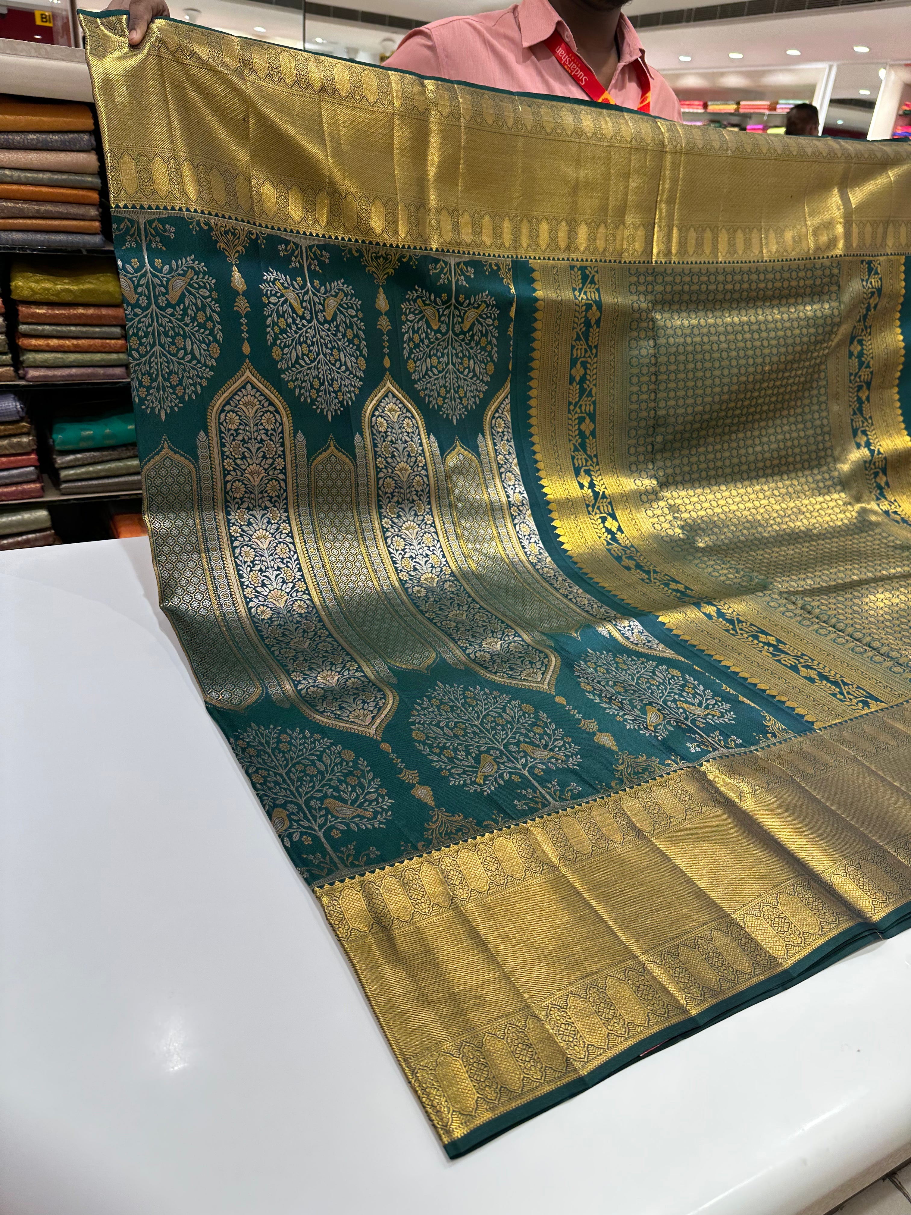 Dark Green Pure Kanjivaram Silk Saree with Silver and Gold Zari Designs. Rich Gold Zari Border adds a Grand Traditional Look.