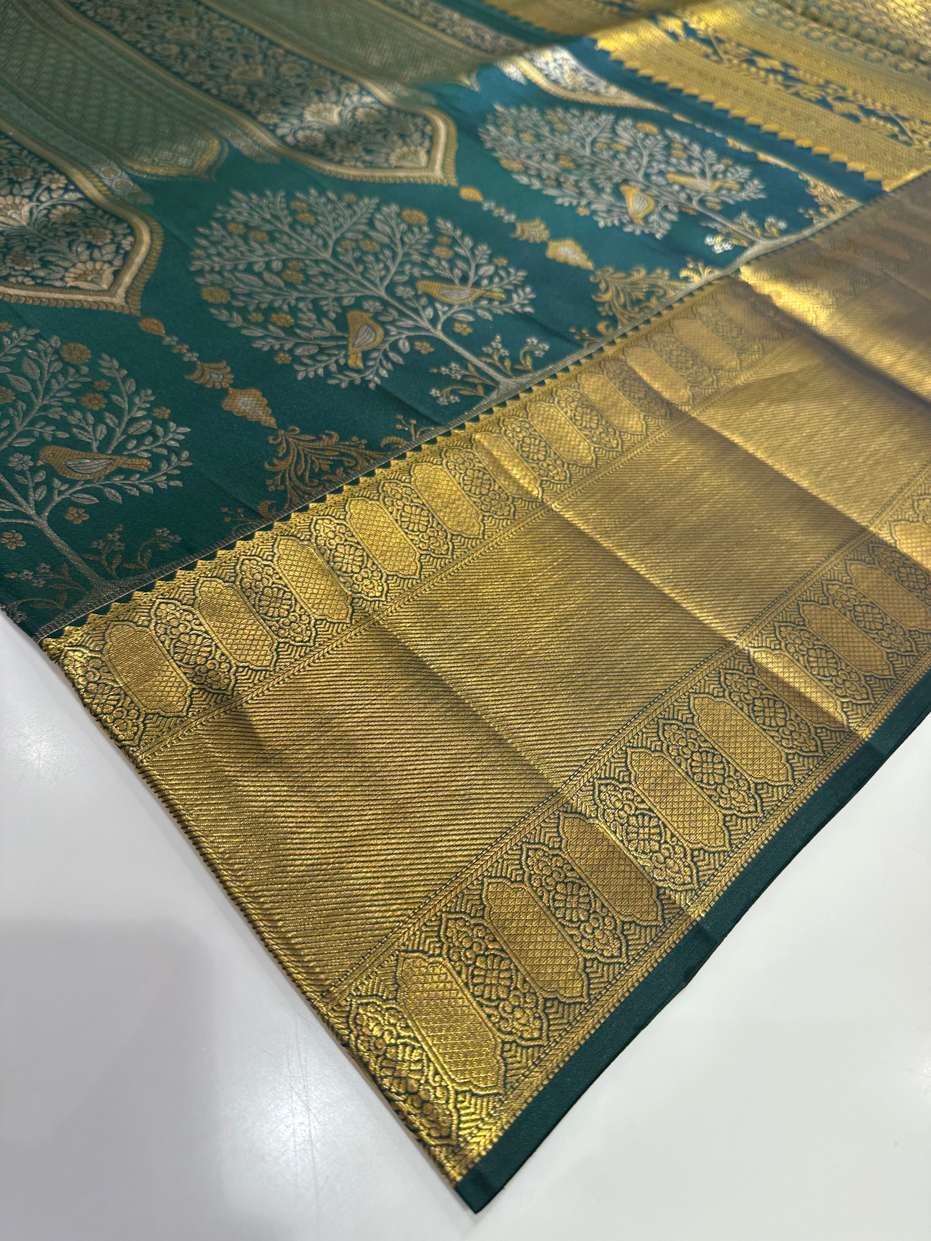 Dark Green Pure Kanjivaram Silk Saree with Silver and Gold Zari Designs. Rich Gold Zari Border adds a Grand Traditional Look.